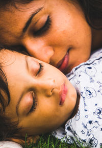 Mother and son sleeping on field