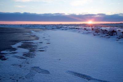 Snow covered beach during sunset