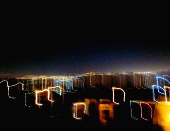 Illuminated city against sky at night