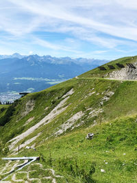 Scenic view of green landscape and mountains against sky