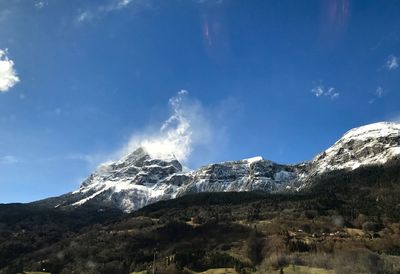 Low angle view of snowcapped mountains against sky