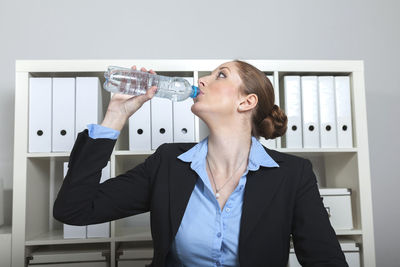 Businesswoman drinking water at office
