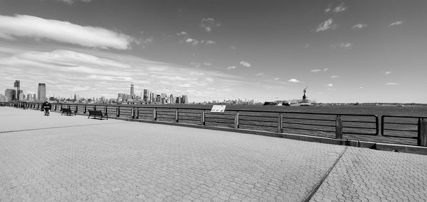 View of city street by sea against sky