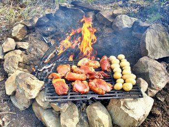 High angle view of meat and potatoes on barbeque