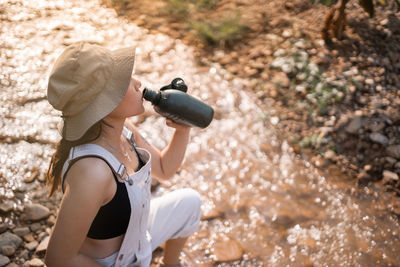 Female tourist drinking water.woman resting with water bottle during hike