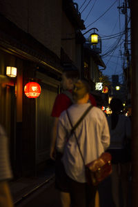 People standing on illuminated street at night