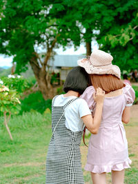 Rear view of women standing against plants