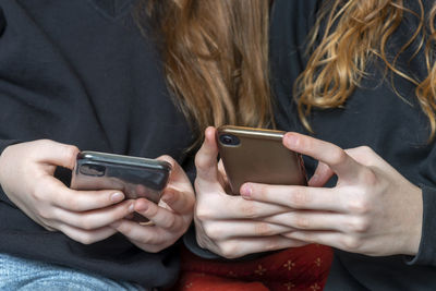 Midsection of females using mobile phone