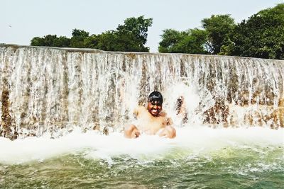 Full length of shirtless boy in water