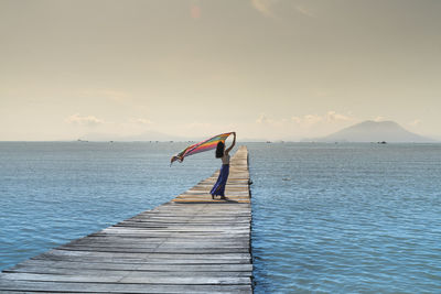 Boy on sea shore against sky