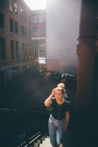 Young woman on walking on steps in city