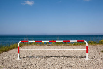 Deck chairs on beach against sky