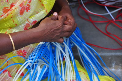 Cropped image of woman making plastic basket