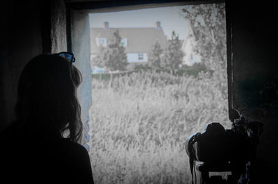 Rear view of woman against window
