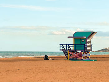 Lifeguard hut on beach against sky