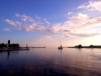 Boats in sea at sunset