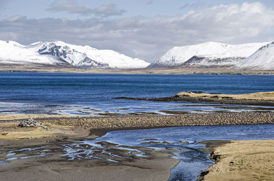 Asphalt road crossing the sandy delta of a little river on the north coast of snaefellsnes peninsula