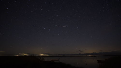 Scenic view of lake against star field at night