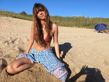 Beautiful young woman lying on sand