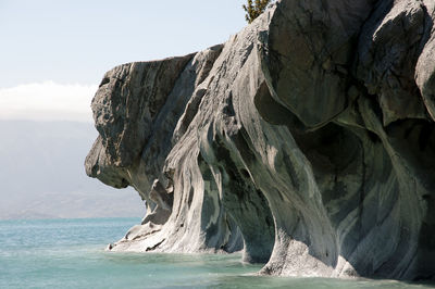 Scenic view of rock formation in sea against sky