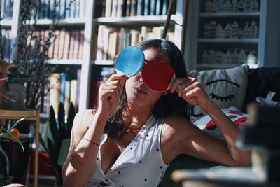 Young woman holding tablet tennis rackets while sitting at home