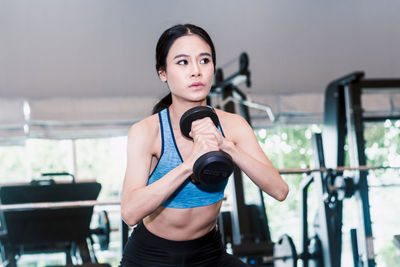 Woman lifting dumbbell in gym