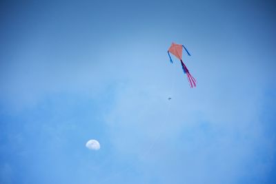 Low angle view of kite flying against blue sky