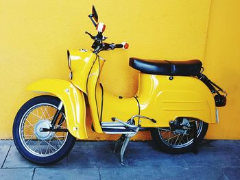 Scooter against yellow wall