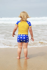 Rear view of child standing on beach