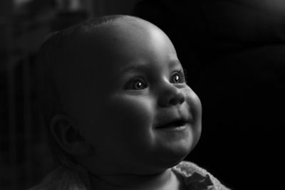 Close-up of cute baby girl looking away
