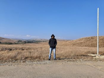 Full length of man standing against blue sky