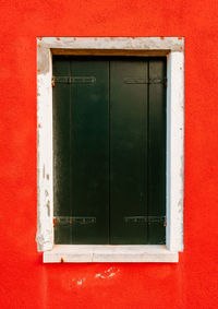 Close up of window on red housing wall