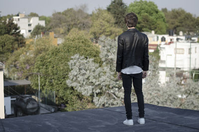 Rear view of man standing against trees
