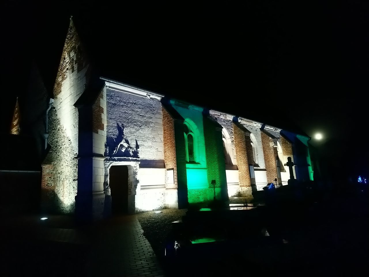 LOW ANGLE VIEW OF ILLUMINATED BUILDING AGAINST SKY