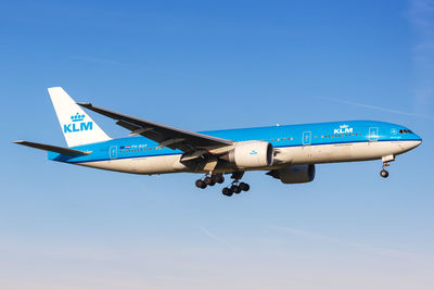 Low angle view of airplane against clear blue sky