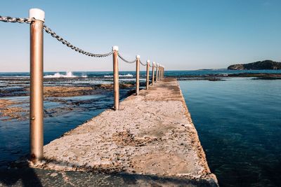 Pier over sea against clear sky