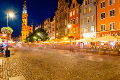 Illuminated city street and buildings at night