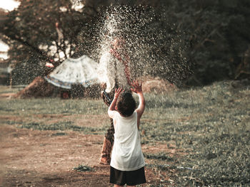 Rear view of boy standing in water