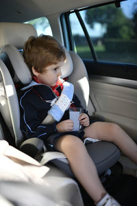 Rear view of boy sitting in car