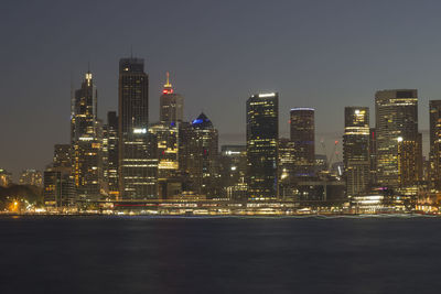 Illuminated buildings in city against sky at night