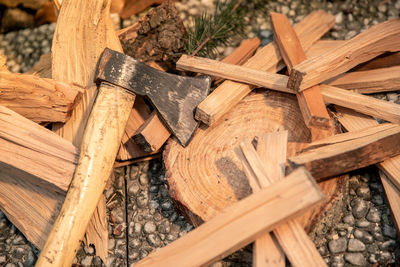 Preparation of wood to light a fire to cook food on grill outdoor. ax and pieces of firewood