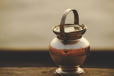 Close-up of old glass container on table