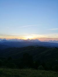 Scenic view of landscape against blue sky during sunset