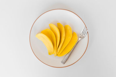 High angle view of yellow fruit over white background