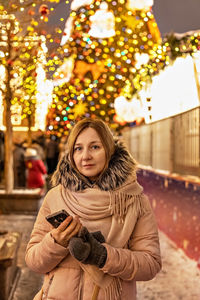 A  woman on the street, in the square with a christmas tree and christmas decorations. new year 