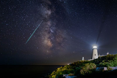 The milkyway and a meteor lights up the night sky off the coast at the pemaquid point lighthouse.  