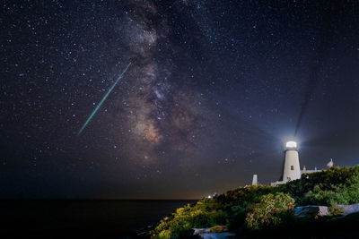 Low angle view of lighthouse against sky at night