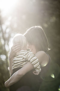 Mother embracing daughter outdoors