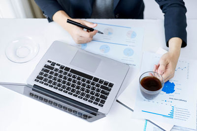 Midsection of man using laptop on table