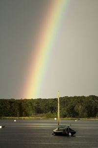 Scenic view of rainbow over sea against sky